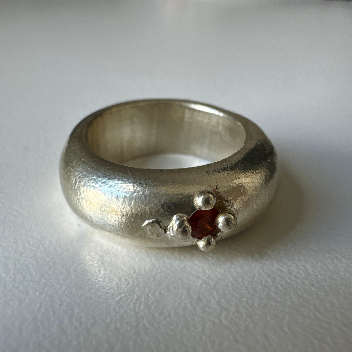 Lost wax silver ring with delicate granulations around an orange cubic zirconia stone