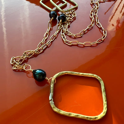 Necklace featuring brass rectangle and squares with black pearls