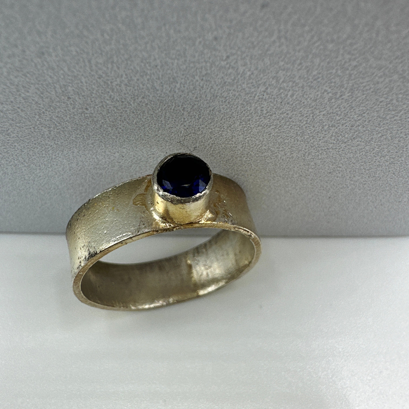 Silver ring reticulated round with lab grown sapphire.