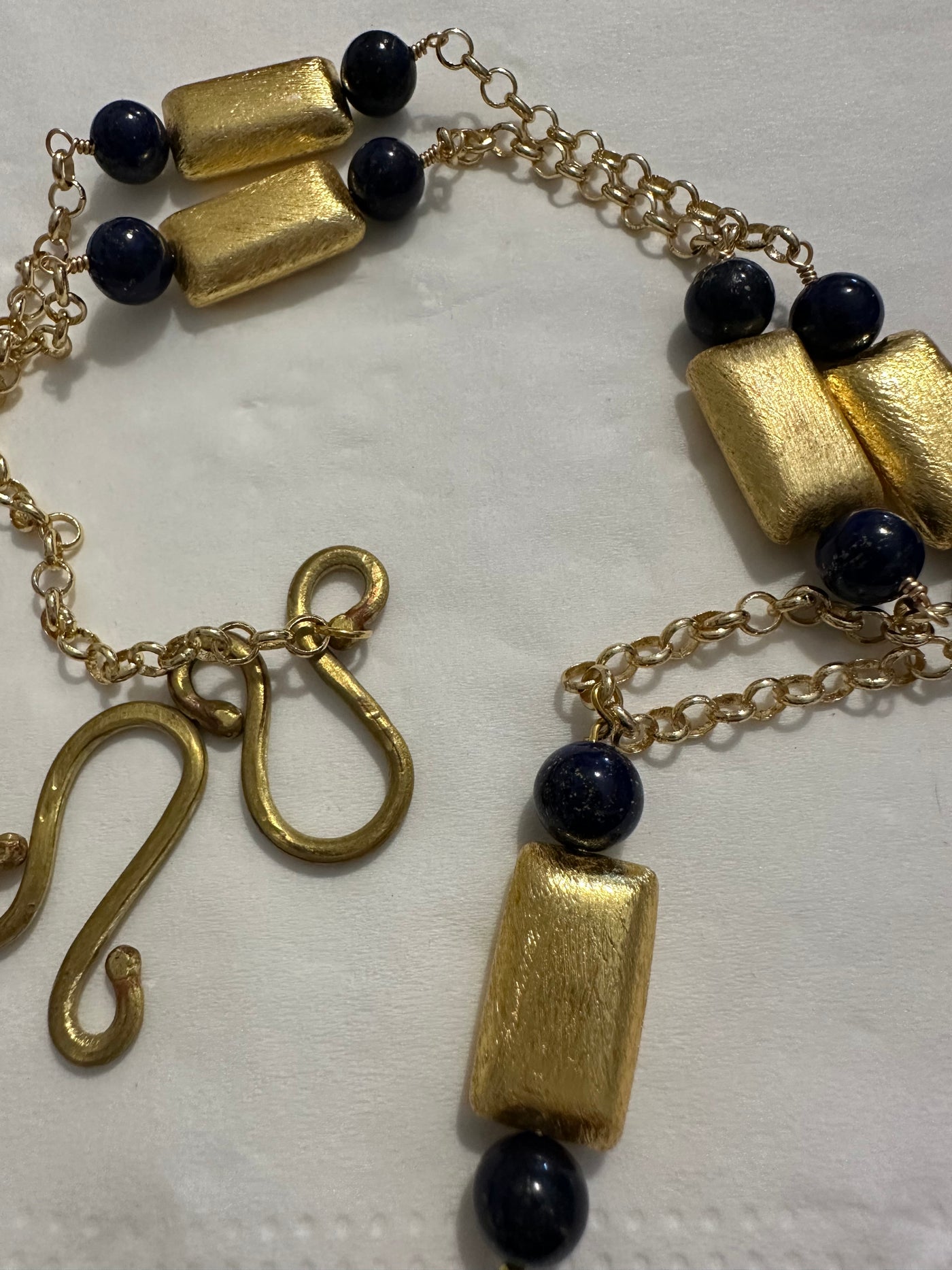 Necklace with dark blue pearls on  brass chain and accents in brushed bronze