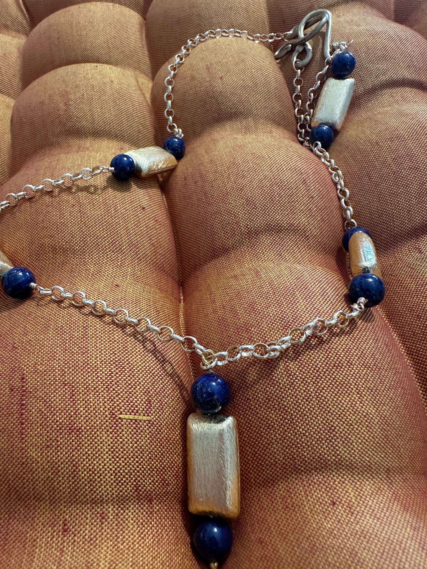 Necklace with dark blue pearls on  brass chain and accents in brushed bronze