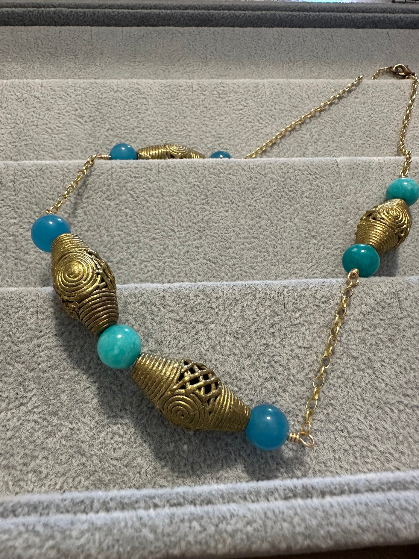 Necklace with brass elements and turquoise jade pearls on brass chain