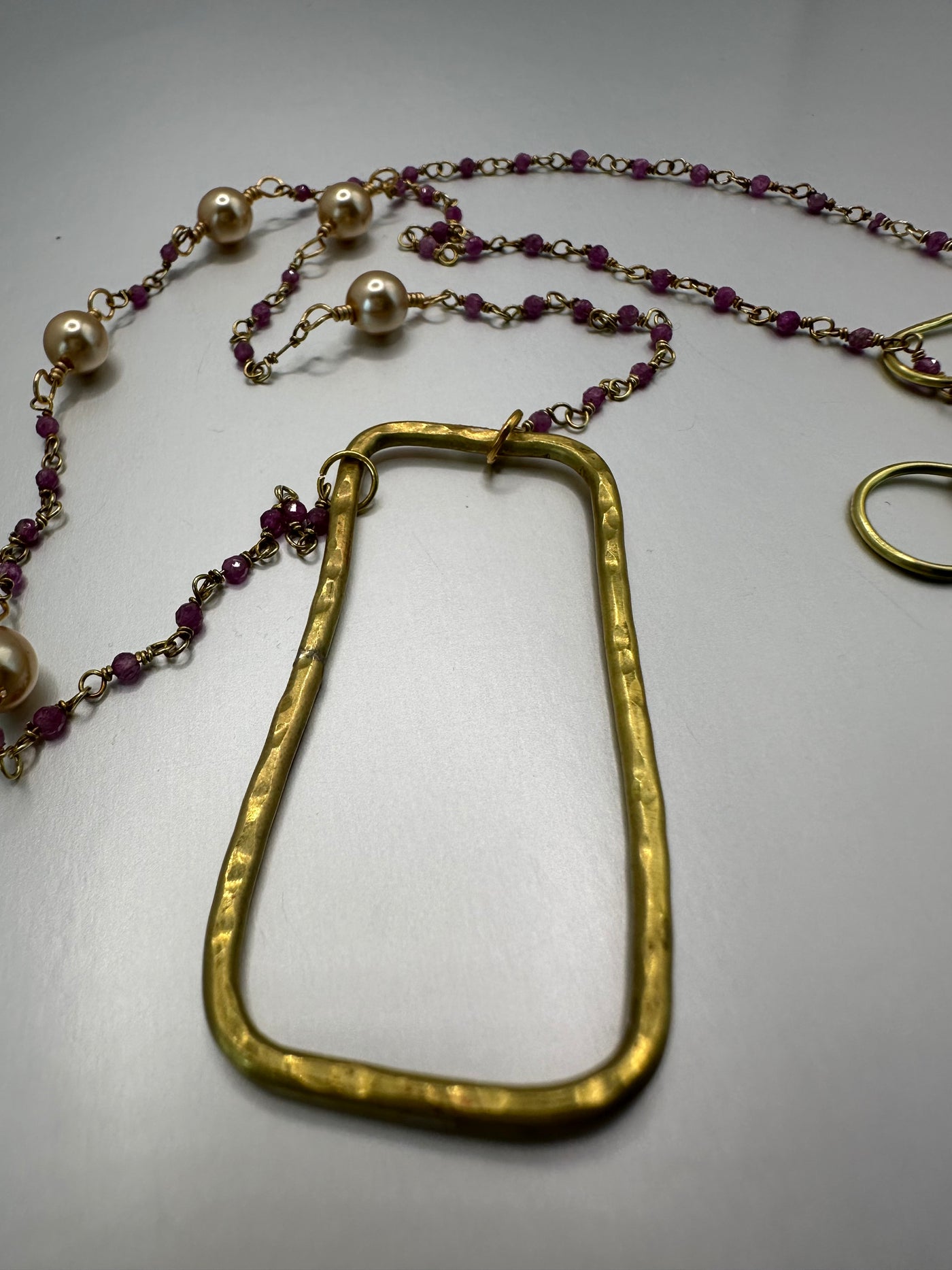 Silver and purple beads with brass rectangular pendant and golden pearls