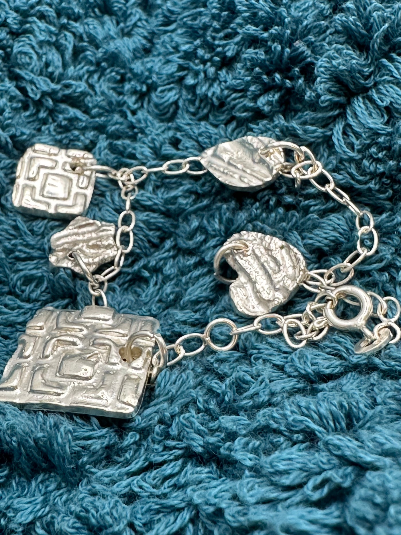 Sterling silver bracelet with 5 small pendants (different shapes and patterns)