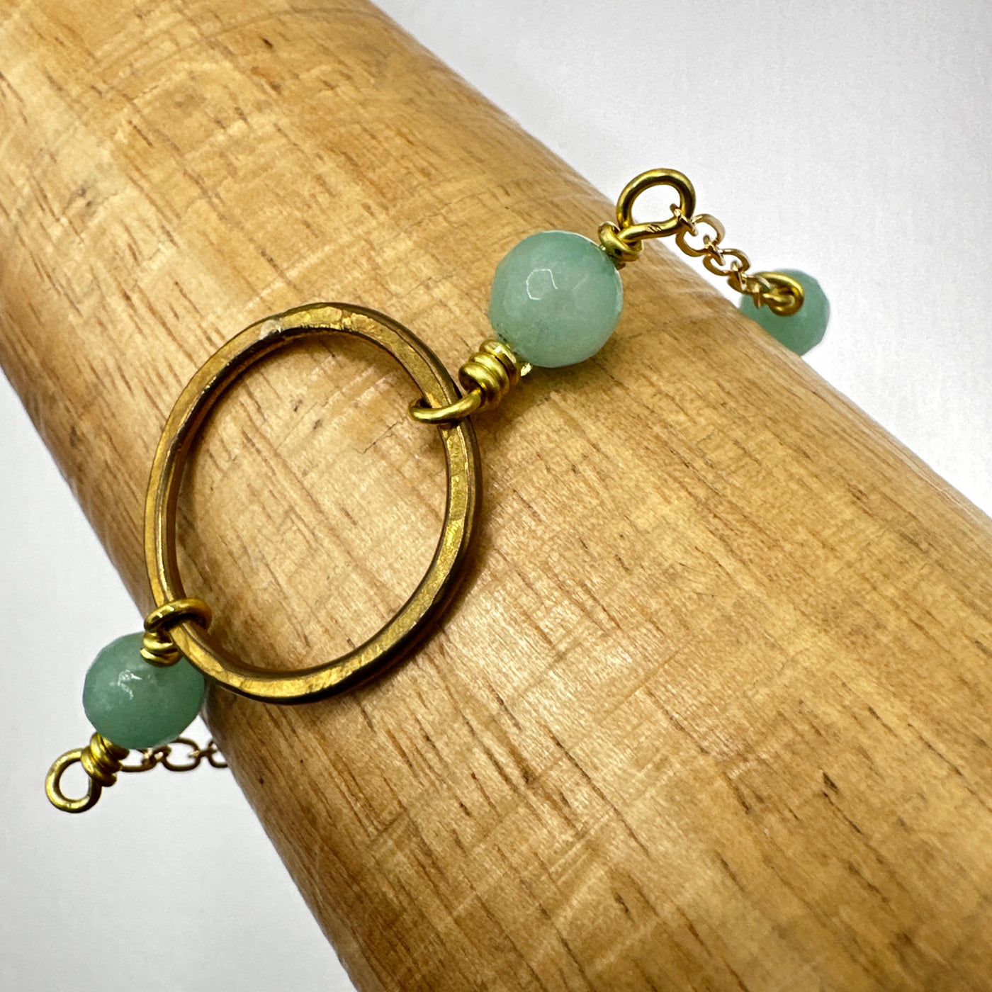 Bracelet with dyed aqua jade faceted round 8 mm beads and brass circle.