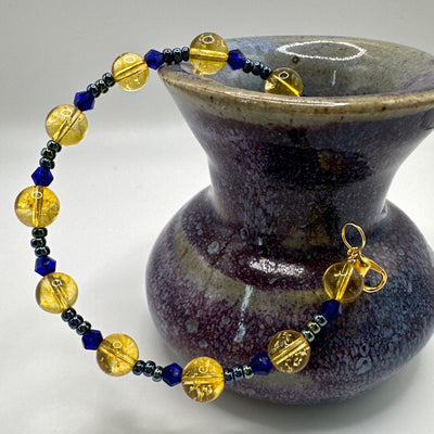 Rigid bracelet with blue faceted glass, citrine and metallic blue pearls