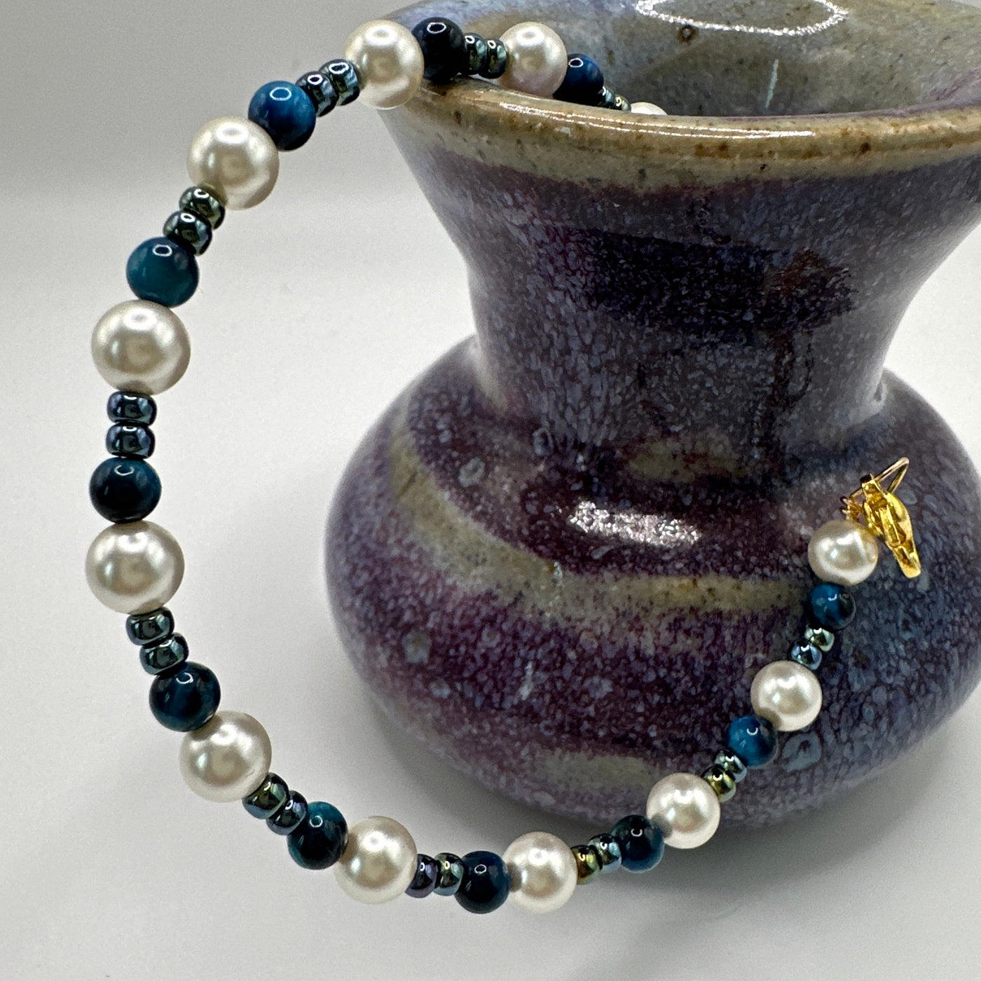 Rigid bracelet with blue tiger eye, white and metallic blue pearls