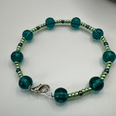 Rigid bracelet with ocean blue round glass and metallic green pearls