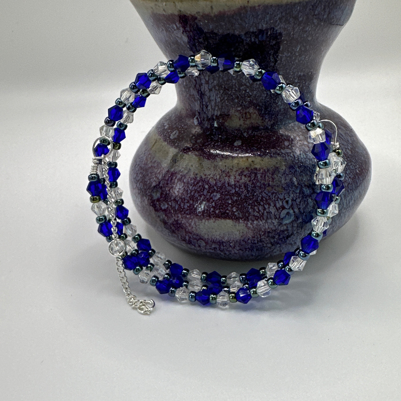 Rigid bracelet with blue and white faceted glass and metallic blue pearls 
