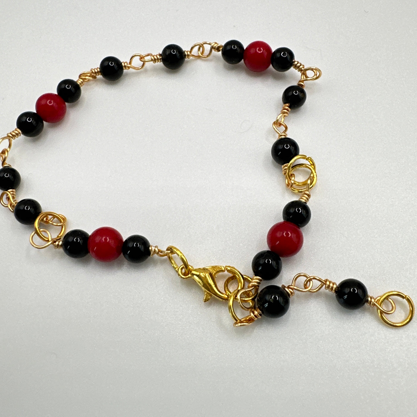 Bracelet in brass and onyx with red corals
