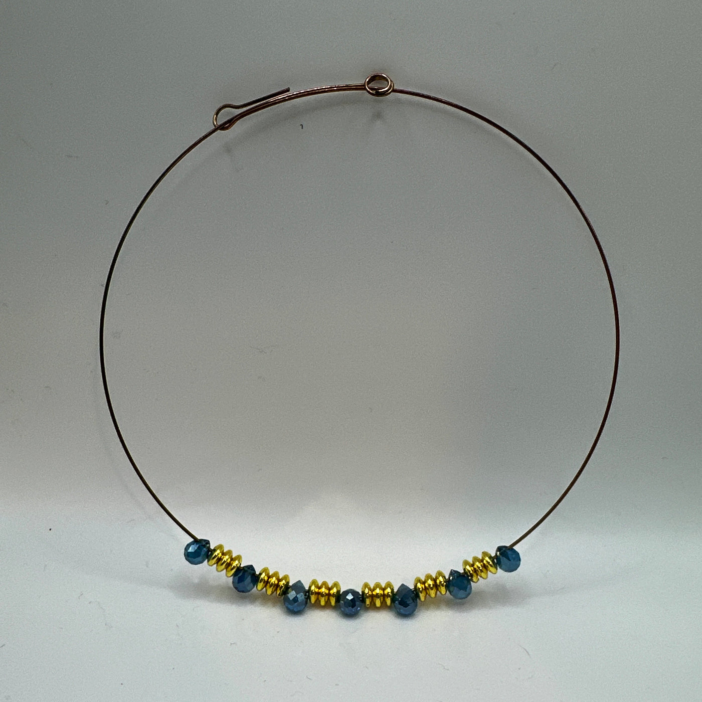Round rigid necklace in steel with brass and blue topaz briolette crystals elements