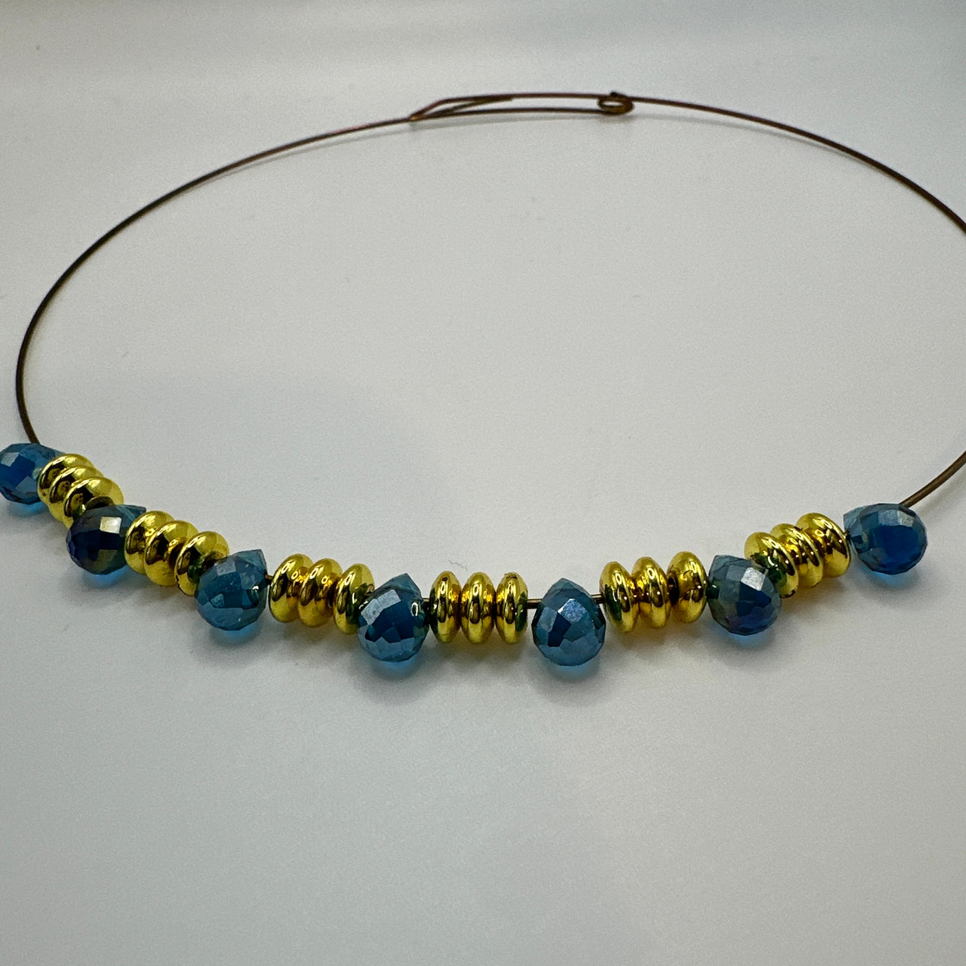 Round rigid necklace in steel with brass and blue topaz briolette crystals elements