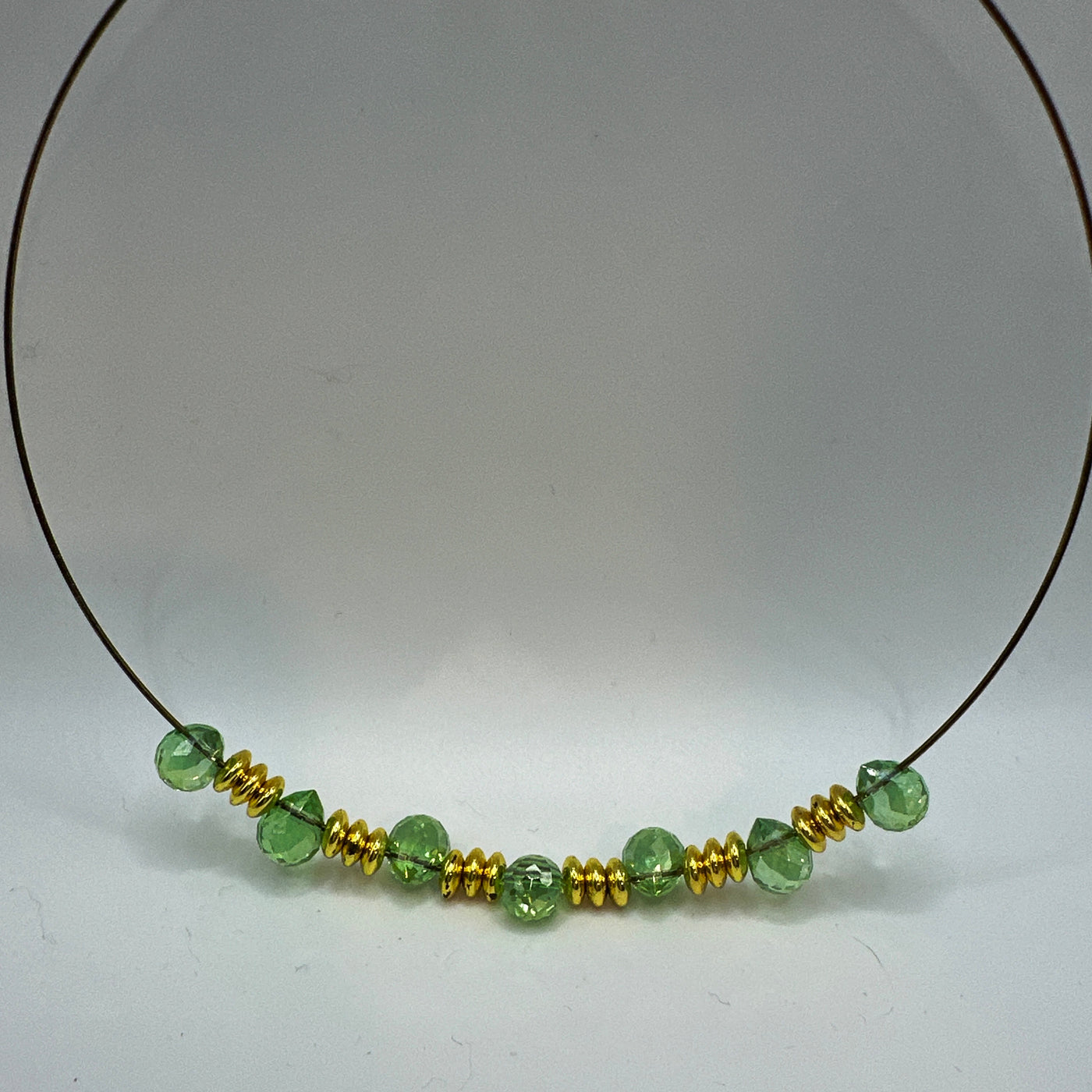 Round rigid necklace in steel with brass and green briolette crystals elements