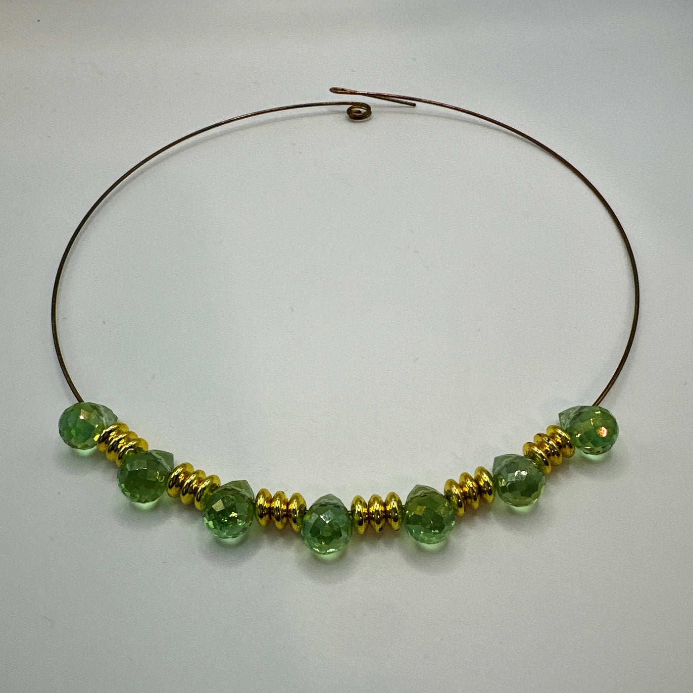 Round rigid necklace in steel with brass and green briolette crystals elements