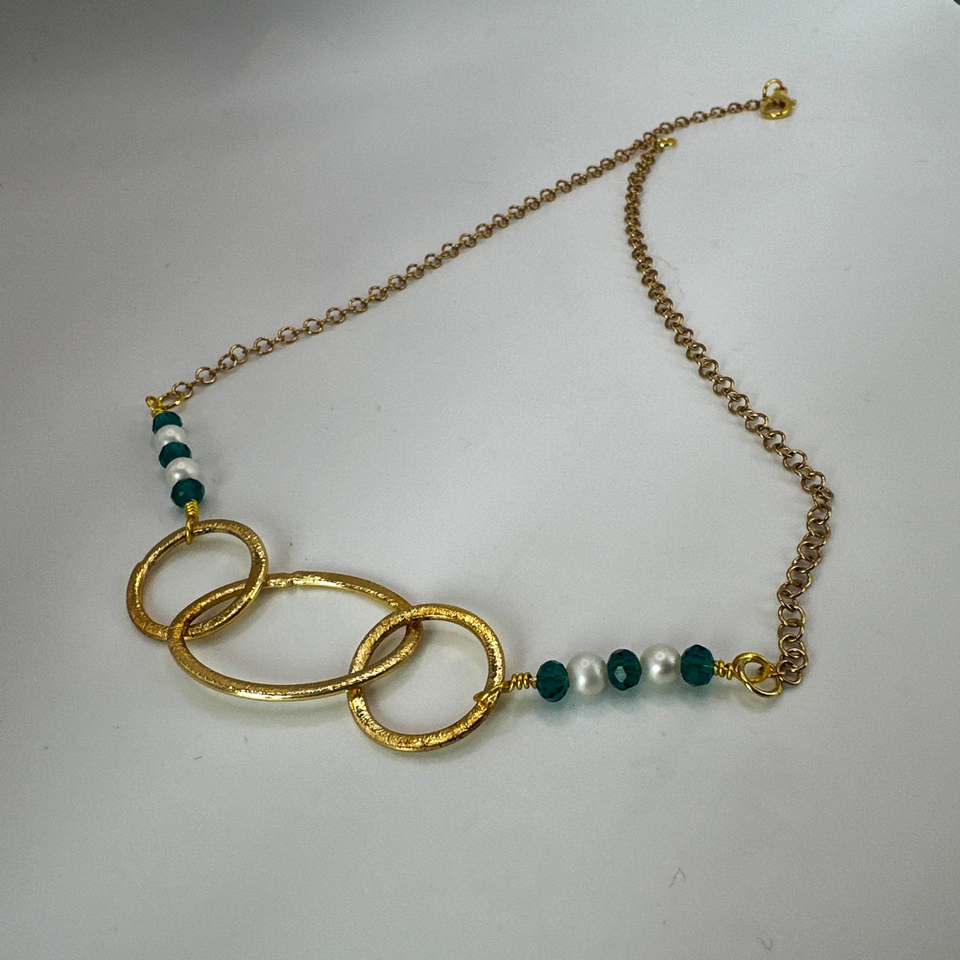 Brass ovals and round with green crystal rondelles and pearls over steel goldwashed chain necklace