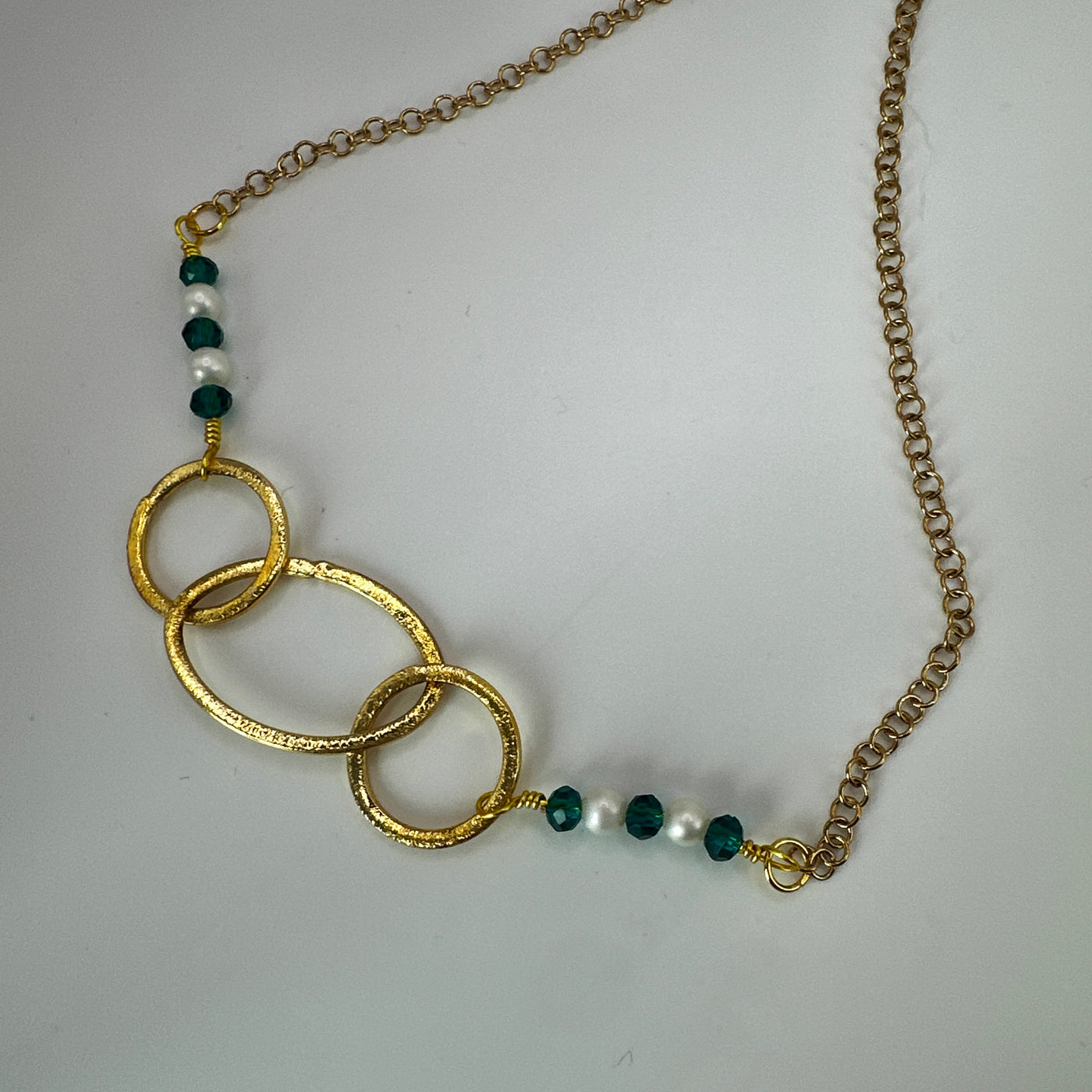 Brass ovals and round with green crystal rondelles and pearls over steel goldwashed chain necklace