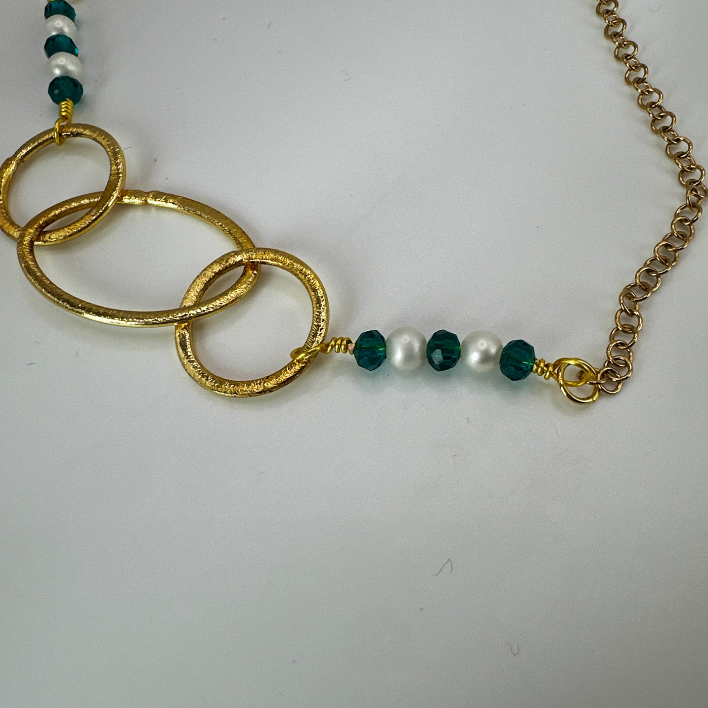 Brass ovals and round with green crystal rondelles and pearls over steel goldwashed chain necklace