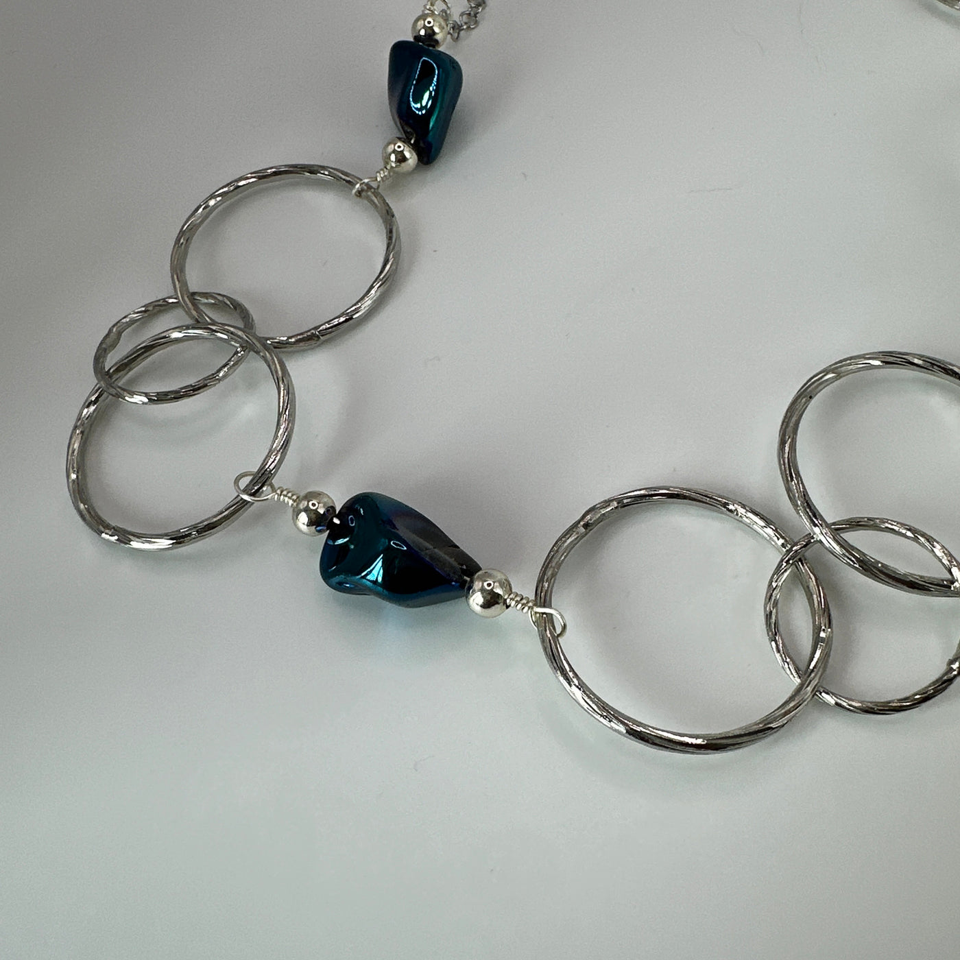 Round brass elements and 'burattato' and galvanized rock crystal peakok necklace