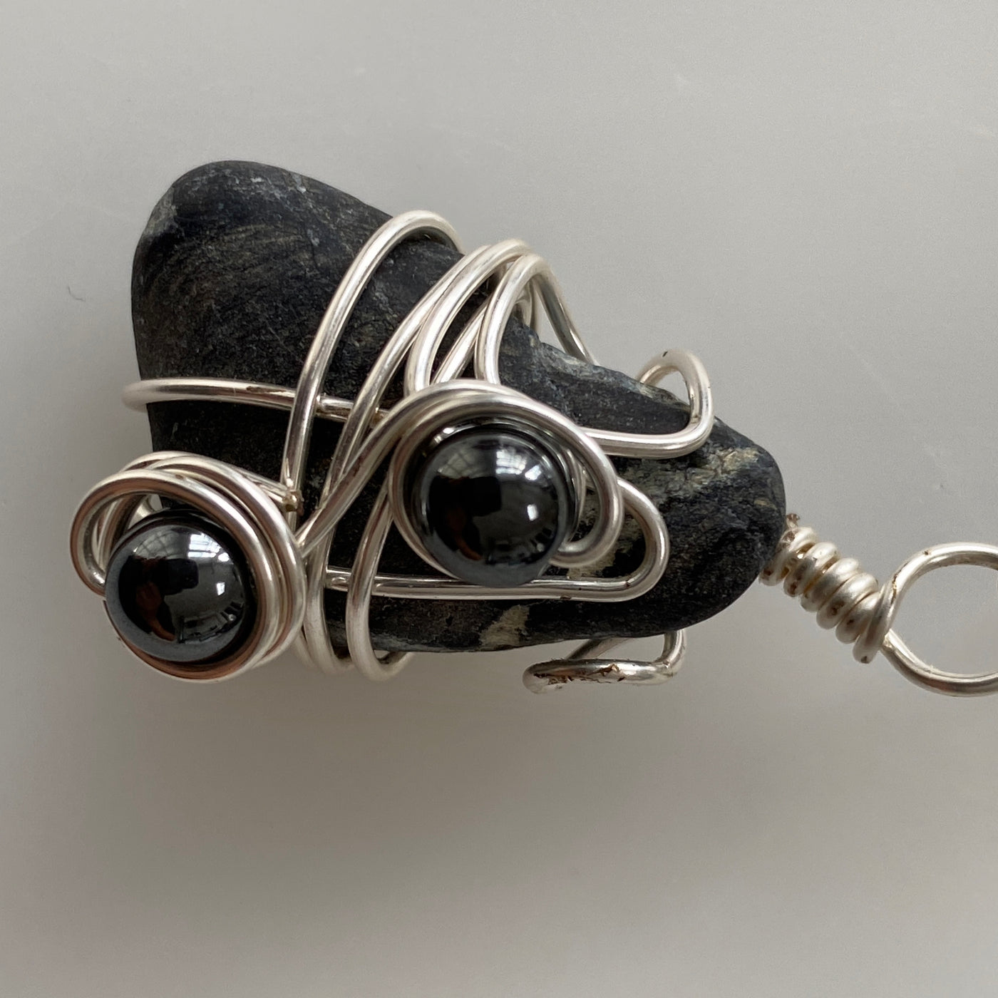 Small pendant with black natural stone, hematite and silver wire. Elbastones.