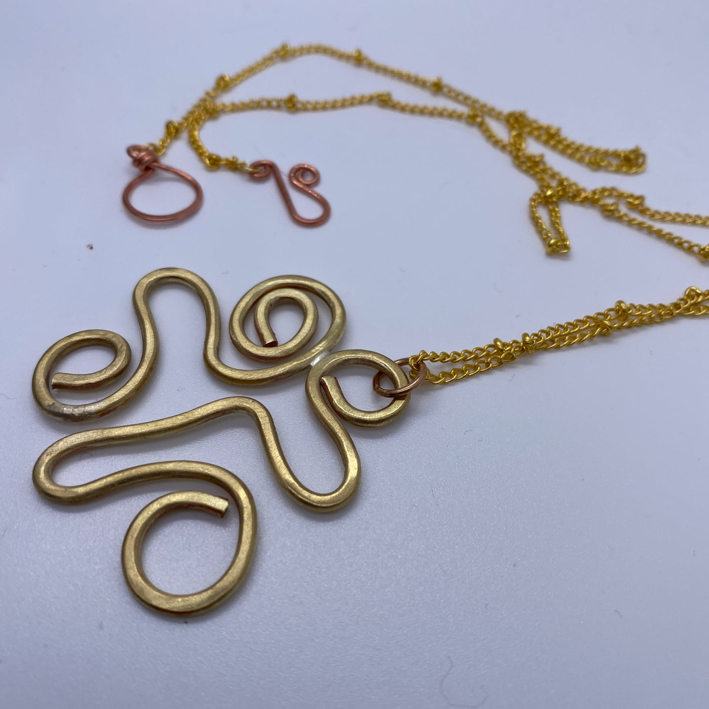 Abstract waves in brass necklace