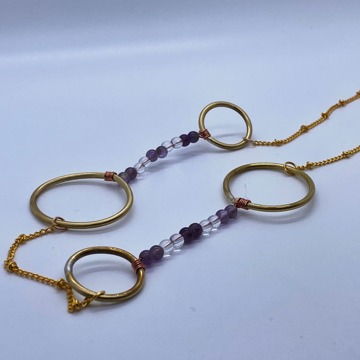 Long necklace: brass circles and ovals, amethysts and quartz