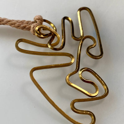 Abstract brass pendant on thick adjustable cord