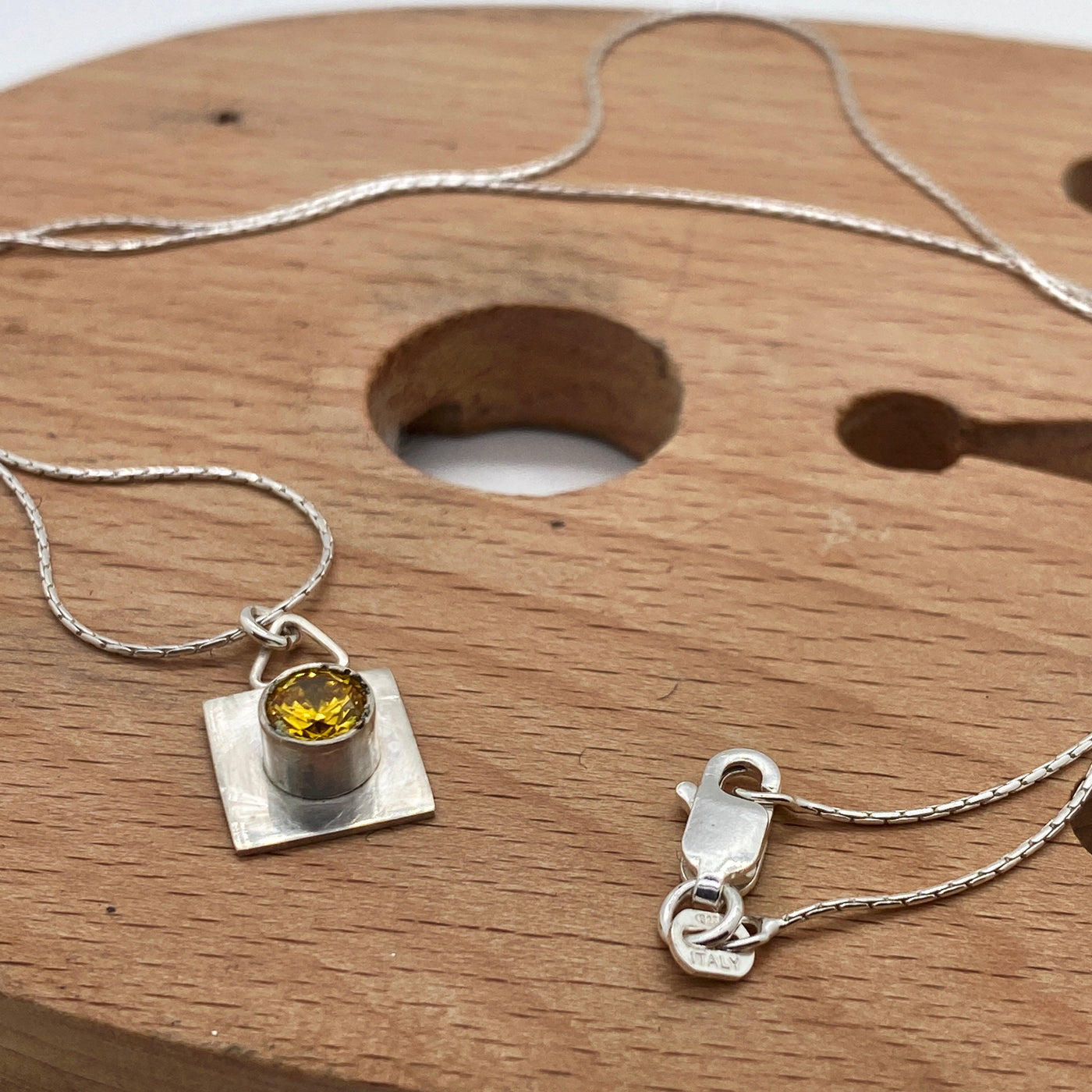 Square sterling silver frame for a tube with yellow cubic zirconia pendant on sterling silver chain
