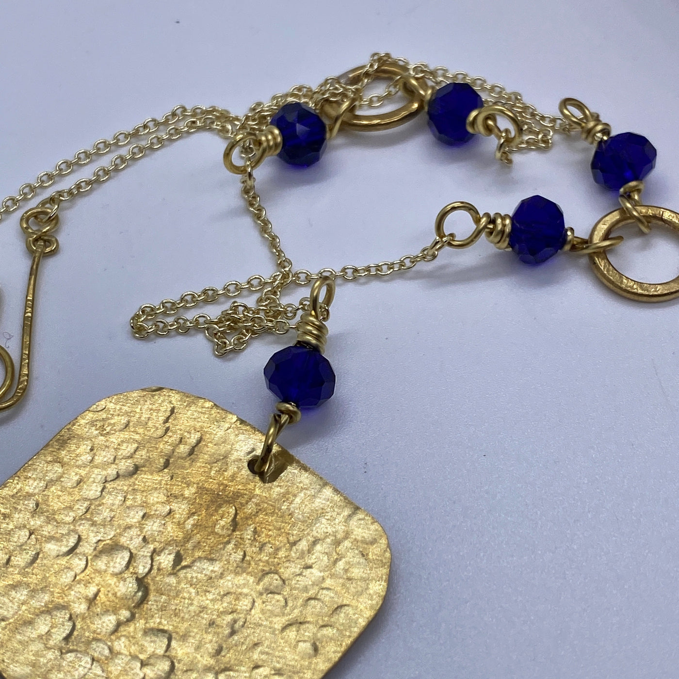 Brass and blue crystal rondelles necklace with hammered pendant