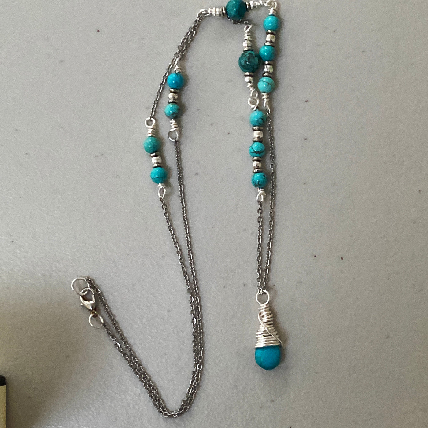Turquoise, African turquoise and blue howlite briolette pendant. This is a long pendant in silver
