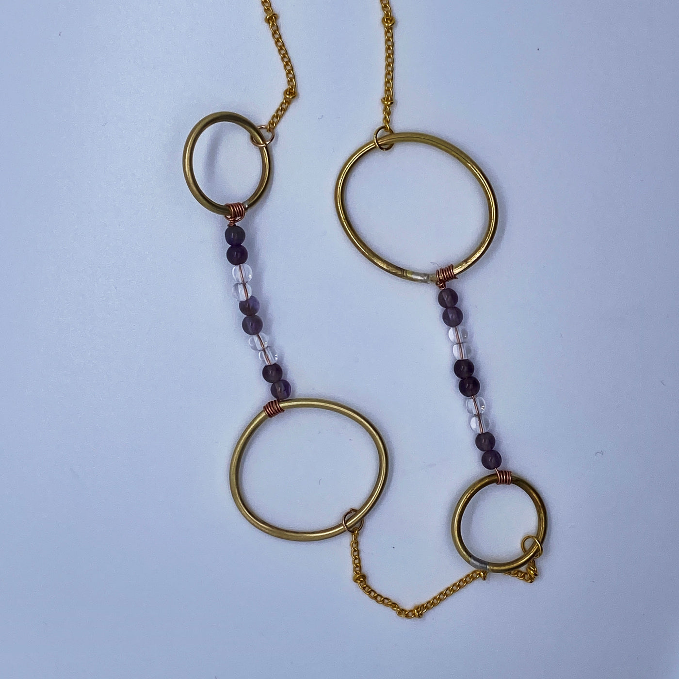 Long necklace: brass circles and ovals, amethysts and quartz