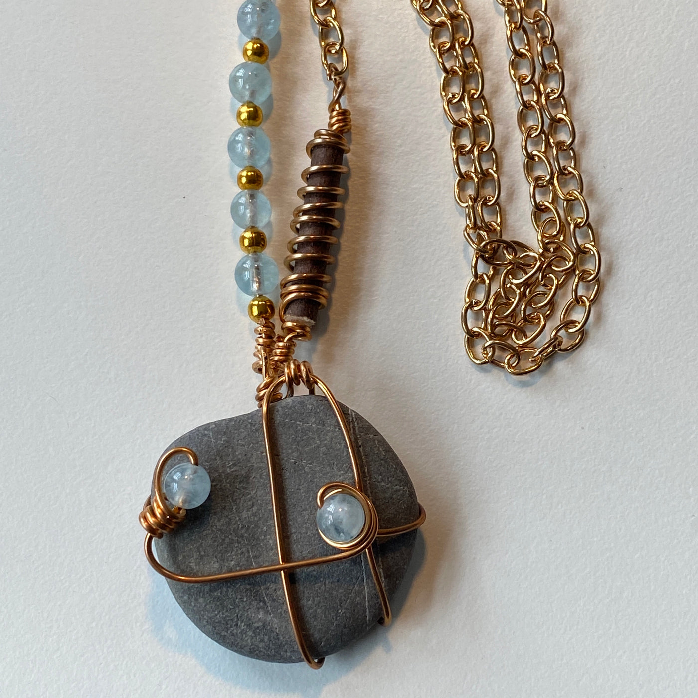 Grey natural stone, aquamarine, wood and wire pendant.
