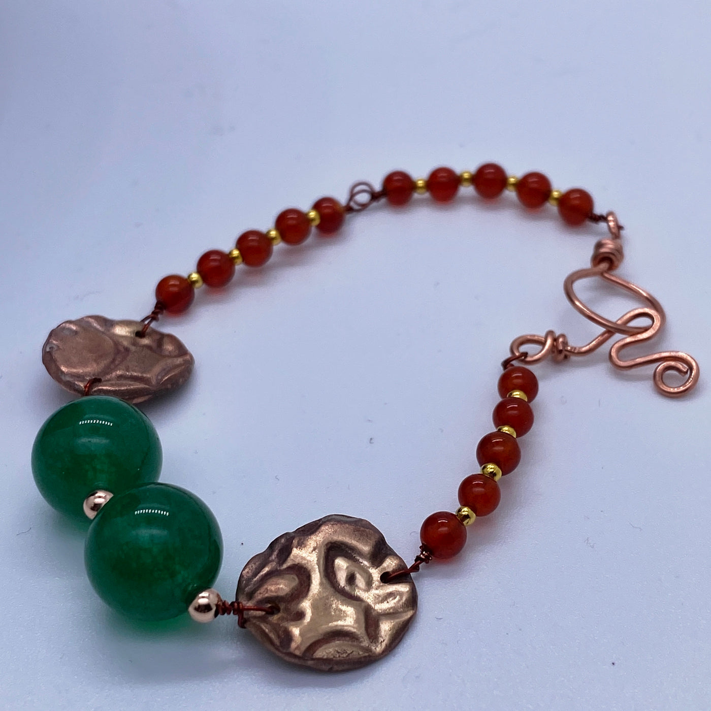 Red agate small pearls and green calchedony big ones, in copper bracelet with bronze textured circles