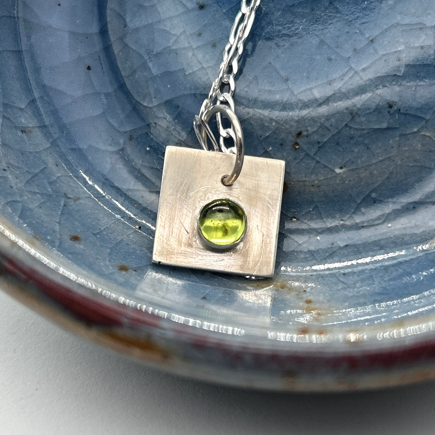 Peridot cabochon 6 mm on silver square pendant mounted on silver chain