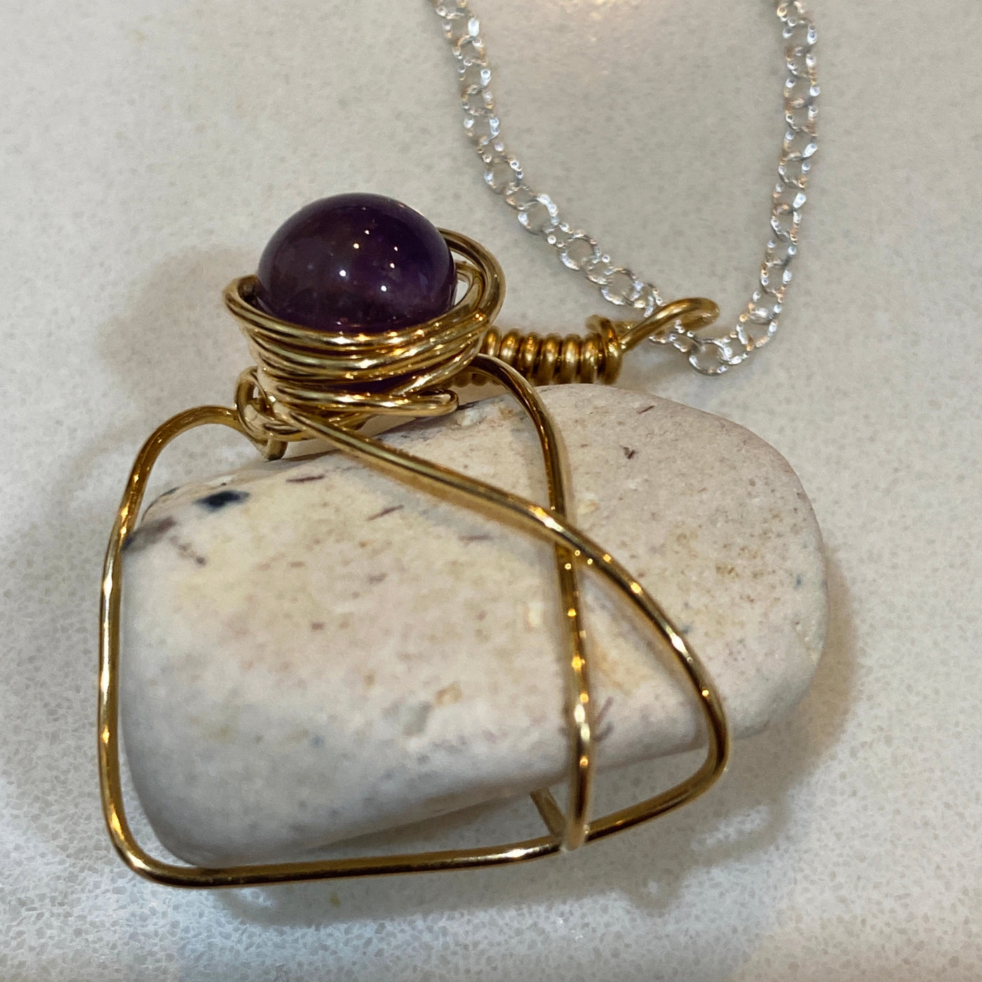 Small elegant pendant in white natural stone, amethist and wire on silver chain.