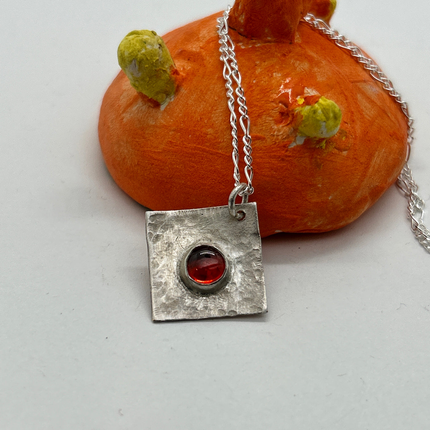 Square hammered 1.5 mm silver pendant with garnet cabochon on silver chain