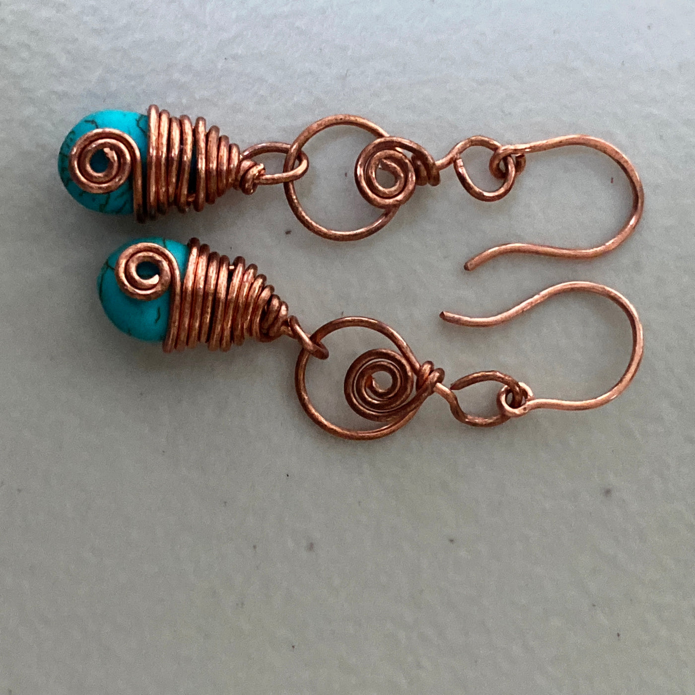 Wire decorated turquoise blue howlite briolette earings.