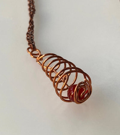 Pendant: Red agate trapped in copper wire