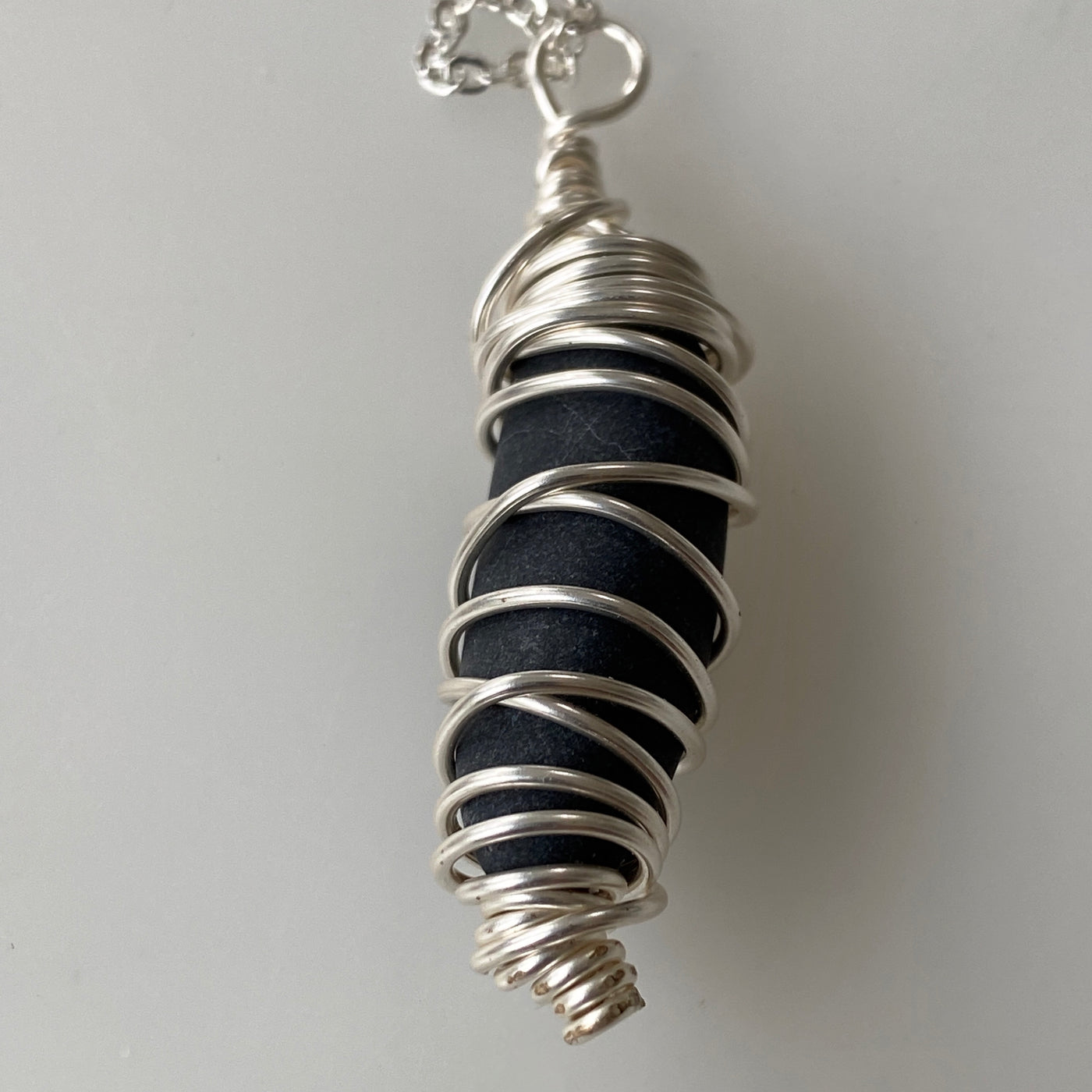 Small black natural stone and silver wire pendant.