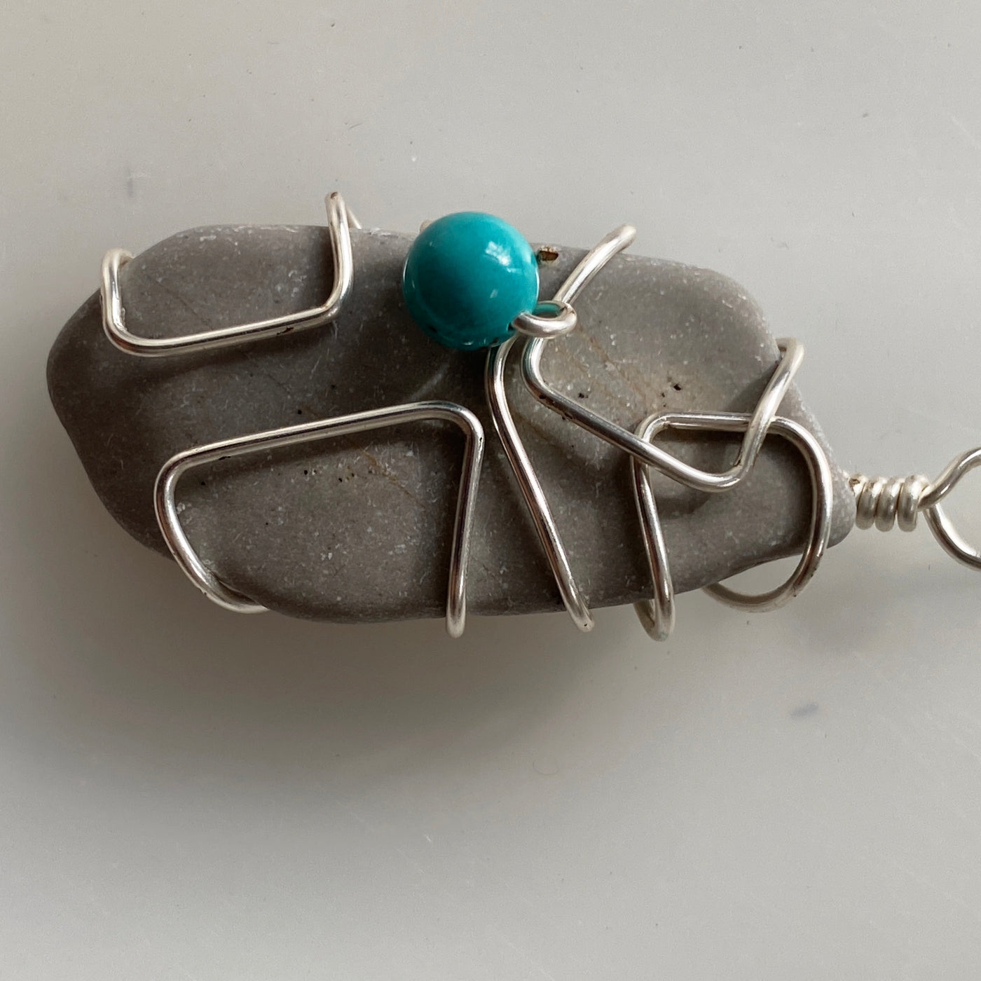 Medium pendant. Grey natural stone, turquoise and silver wire. Elbastones collection.