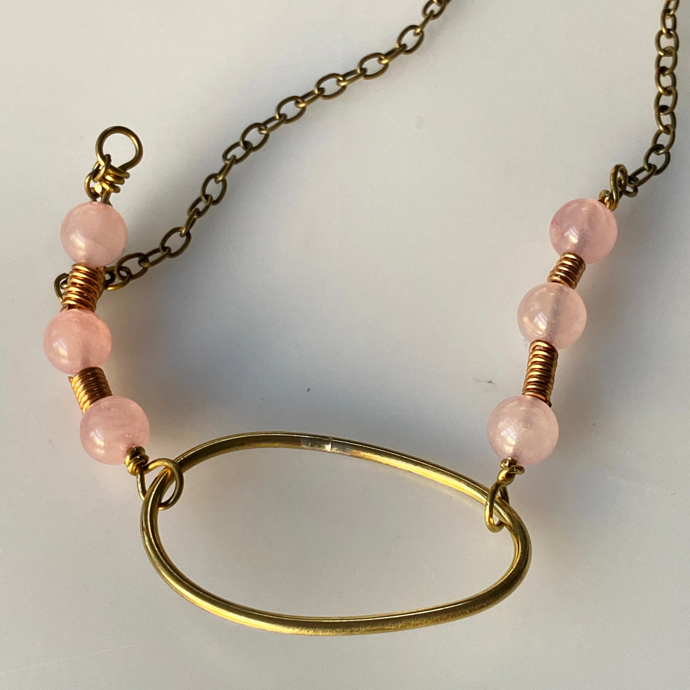 Ovale Halskette aus Rosenquarz und Kupfer.