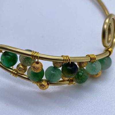 Adjustable brass bracelet with green giada pearls